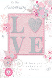 This anniversary card offers a gentle celebration of enduring romance, as if it has been placed on a South Ruislip coffee table ready to accompany a fresh bouquet. The design blends soft pastel pinks with silky greys and accents of pearlescent white, creating a feeling of treasured intimacy. At the centre, the word LOVE is elegantly spelled out in soft, raised glitter, each letter edged with a subtle shimmer. The letter O is replaced by a small, shimmering heart textured in silver tones, adding a focal point that draws both the eye and the fingertips. Around this central motif, delicate blooms unfurl in shades of blush, mauve and creamy white, their petals rendered with an almost watercolour softness. Fine, flowing lines suggest the contours of each flower, while slender stems and curls of foliage weave in and out, recalling the loose, romantic style of an English spring garden-something you might imagine just beyond the quieter streets leading from Long Drive. Tiny flourishes-scattered petals, graceful swirls and almost-hidden butterflies-add a sense of movement and lightness, as if a breeze has just passed through. The background holds a muted blush tone that supports the artwork without competing with it, allowing the glittered LOVE and heart to remain the star. The phrases On Our Anniversary and I love you today and always appear in an understated, graceful script, their curves harmonising with the swirling vines. Altogether, the composition carries a lovely sense of occasion: intimate, romantic and perfectly suited to mark a shared journey in South Ruislip, soft as a whisper yet deeply heartfelt, like an exchanged glance across the table during a quiet anniversary dinner at home.